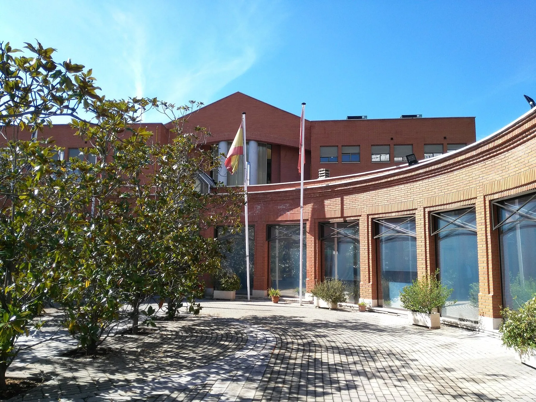 Fachada de ladrillo del Instituto Cajal con árboles delante