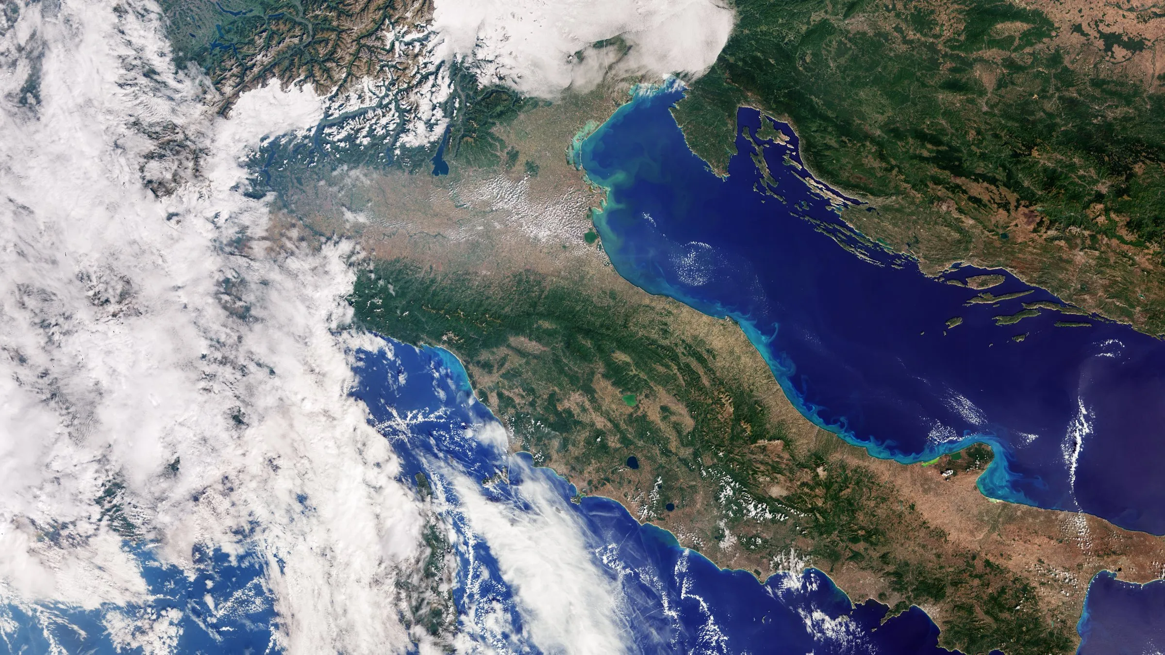 Imagen de satélite de la península italiana, con los Alpes nevados al norte y el mar Mediterráneo alrededor